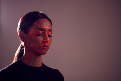 Facial Recognition Technology Concept As Woman Has Red Grid Projected Onto Face In Studio