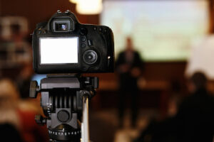 photo video camera with empty white screen in audience recording