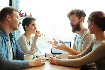 Group of analysts brainstorming and listening to young manager